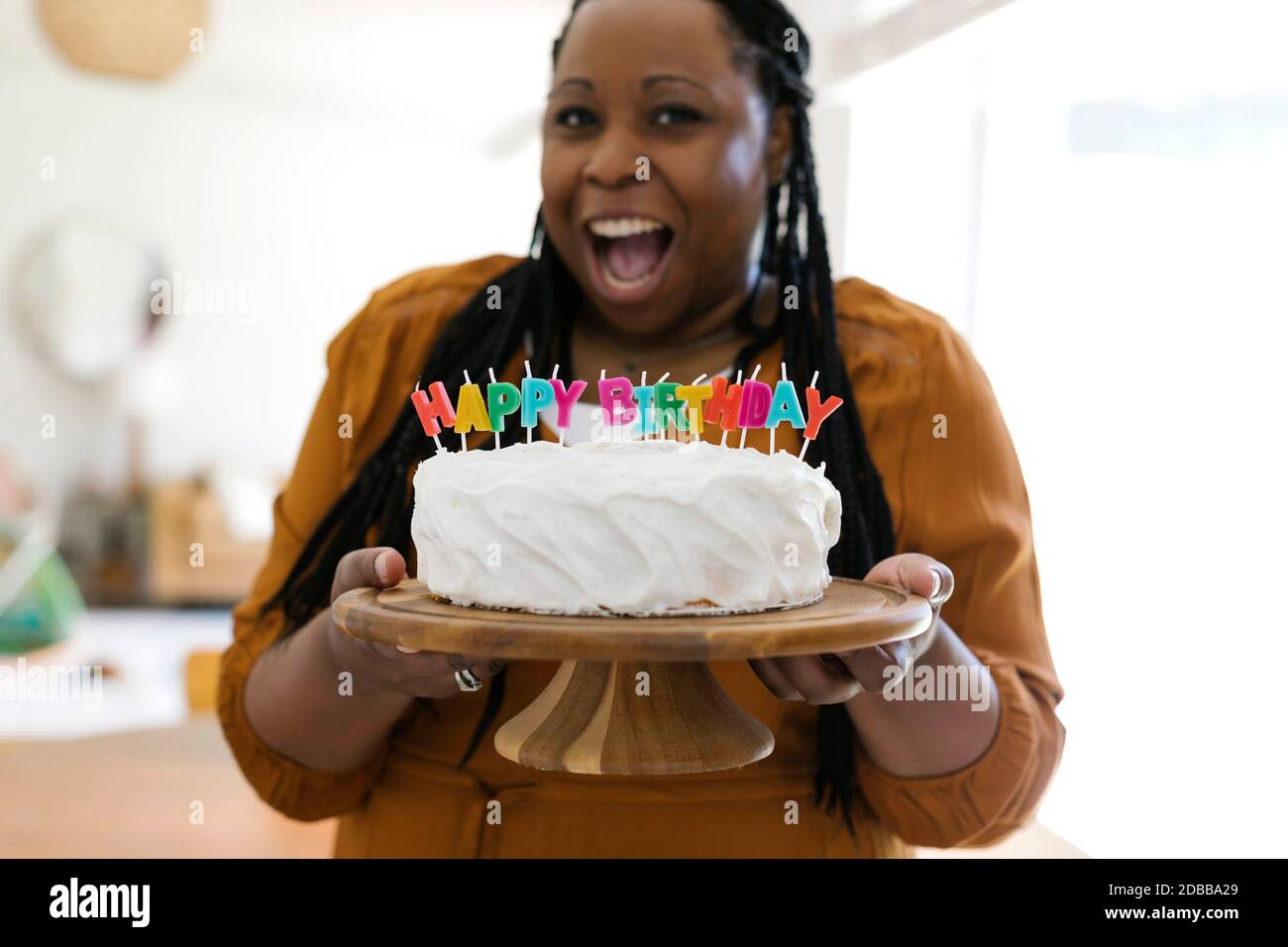 Portrait d'une femme souriante tenant un gâteau d'anniversaire avec des bougies Banque D'Images