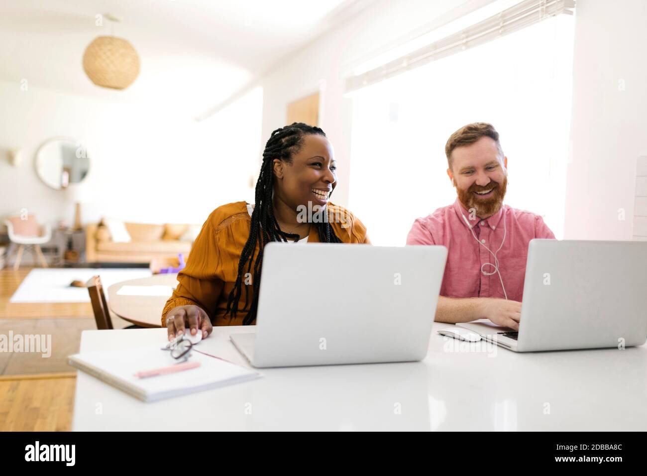 Homme et femme travaillant avec des ordinateurs portables au bureau à domicile Banque D'Images