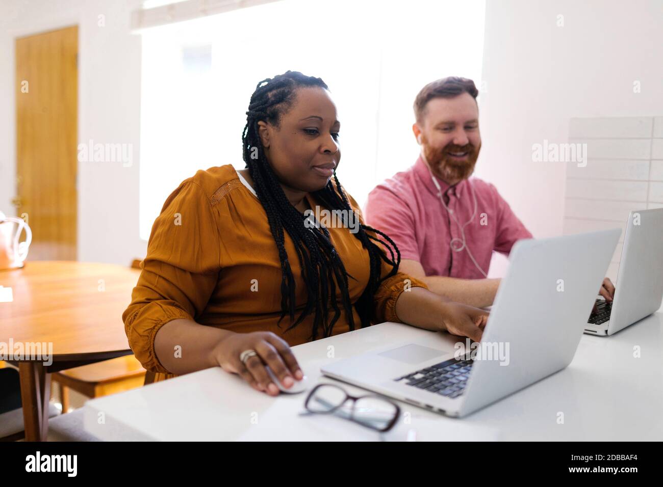 Homme et femme travaillant avec des ordinateurs portables au bureau à domicile Banque D'Images