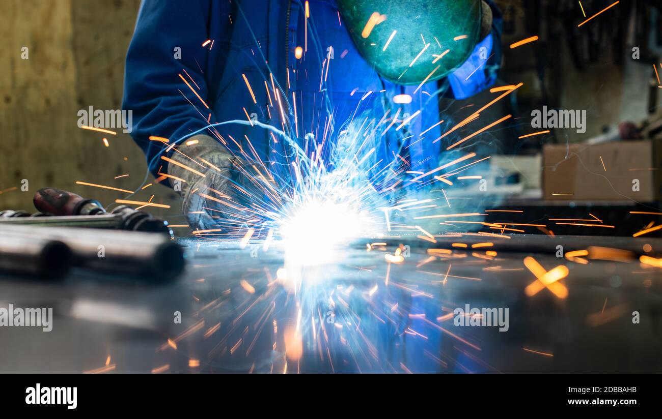 Dans son atelier de soudage welding metal, beaucoup d'étincelles voler autour Banque D'Images