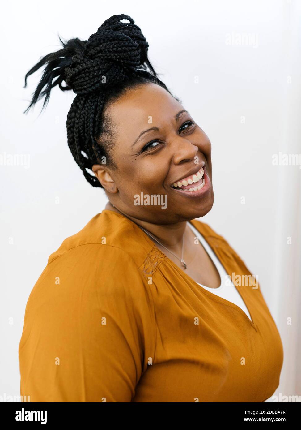 Portrait d'une femme souriante aux cheveux tressés noirs Banque D'Images
