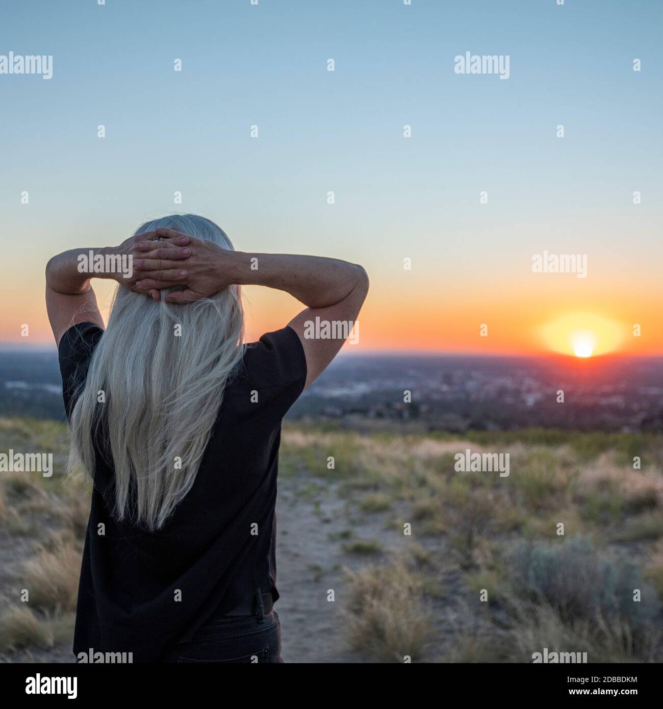 USA, Idaho, Boise, femme regardant le coucher du soleil Banque D'Images