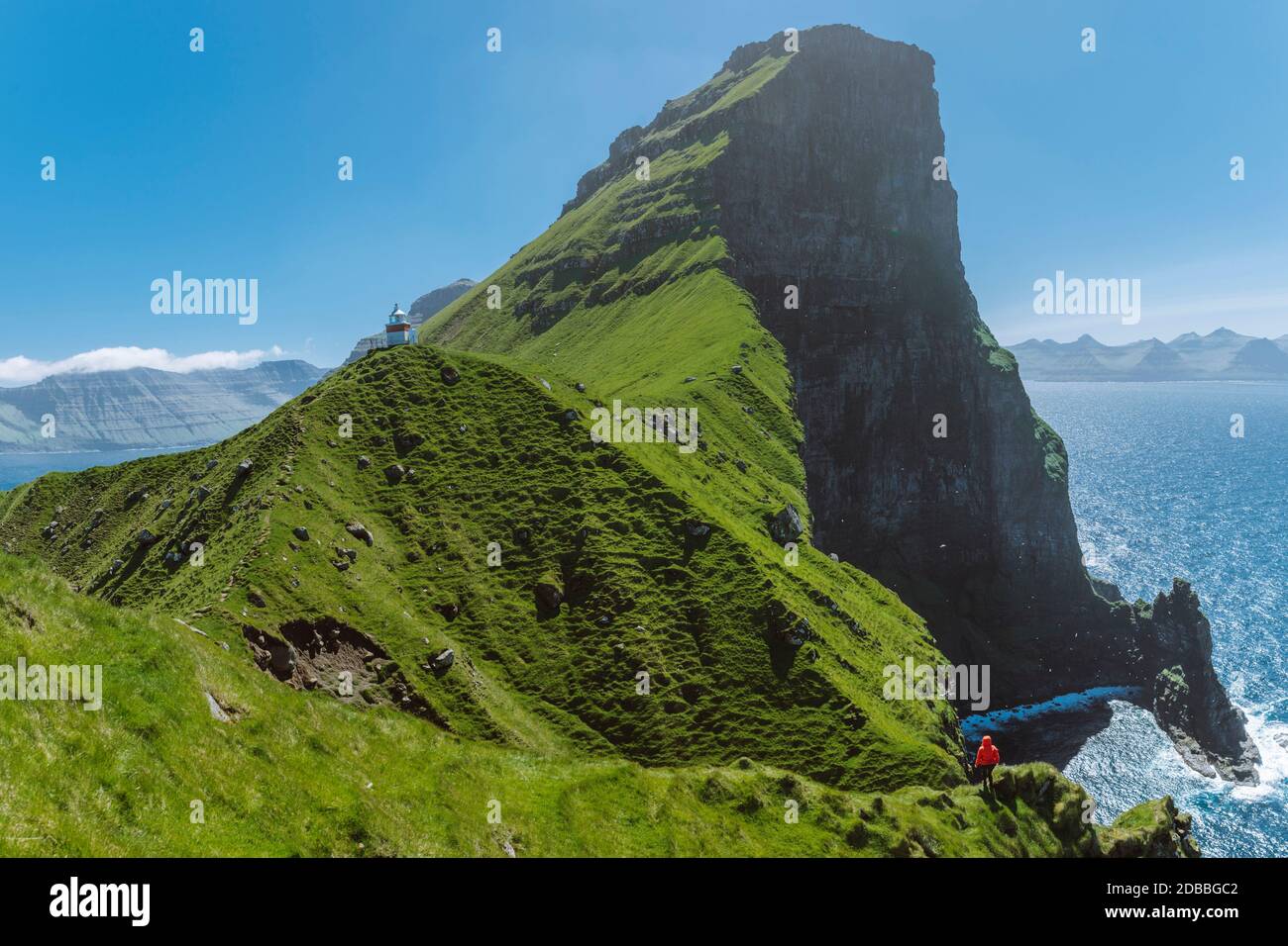 Danemark, îles Féroé, Klaksvik, Trollanes, femme debout sur la falaise et regardant le phare de Kallur Banque D'Images