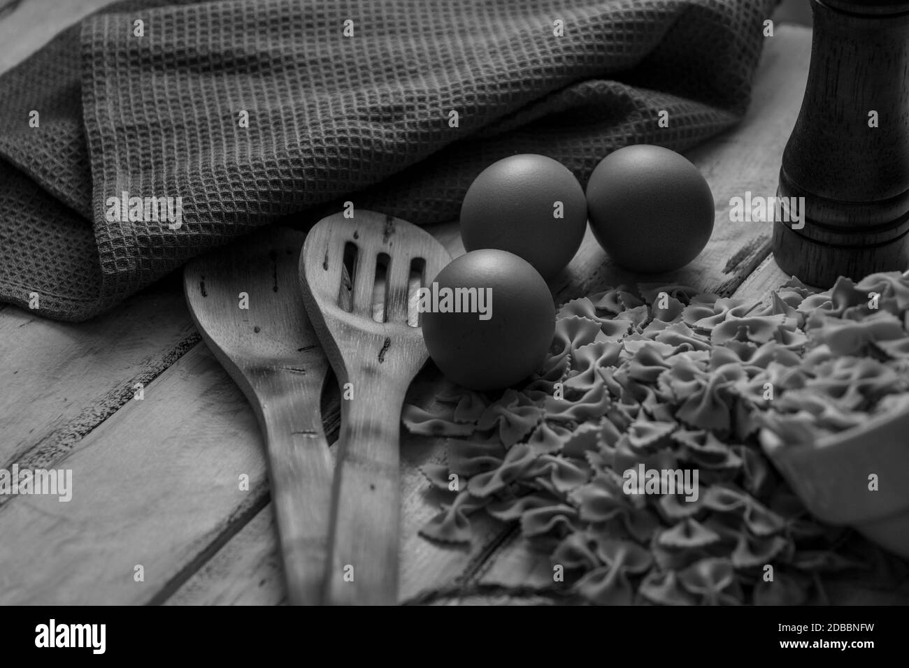 séchez les pâtes sur du bois rustique et les œufs frais en noir et blanc Banque D'Images