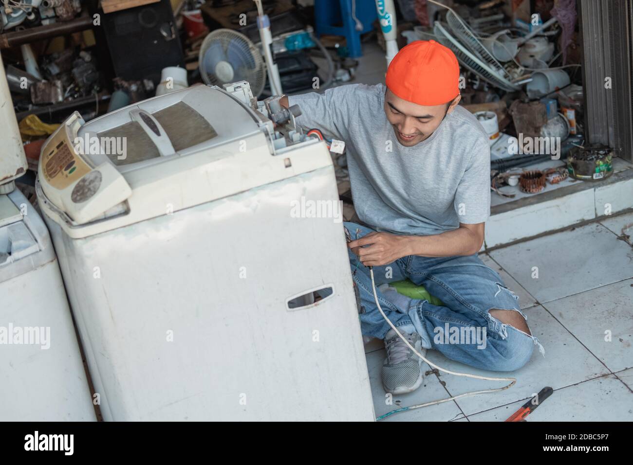 Un travailleur de l'électronique asiatique de sexe masculin fixe le câblage  cassé de la machine à laver au point un atelier de réparation électronique  Photo Stock - Alamy