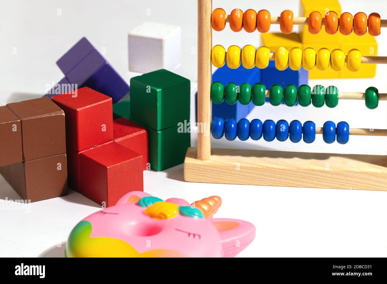Jouets pour enfants blocs en bois colorés, abacus et jouets antistress Donut unicorn sur blanc Banque D'Images