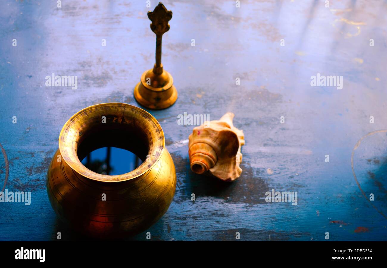 Gros plan Still Life of Antique Holi pot d'eau et cloche et Conch Shell sur un sol rustique. Foi, Tradition, spiritualité, prière, symboles de paix et R Banque D'Images