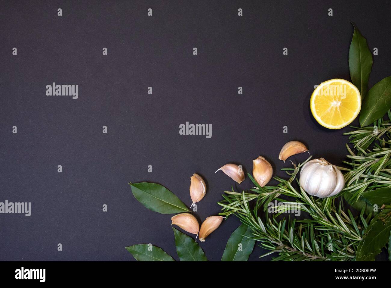 Cadre alimentaire avec brins de romarin, feuilles de Laurier, demi-citron et gousses d'ail, modèle de conception Banque D'Images