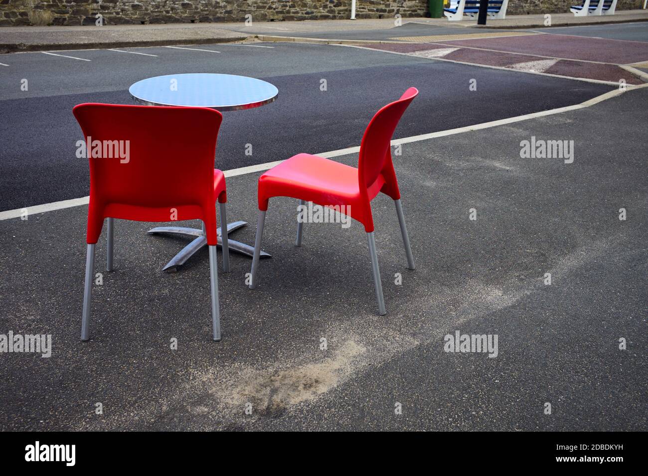 Deux chaises rouges et une table dans un café situé sur la terrasse en bord de mer à Port Erin, sur l'île de Man Banque D'Images