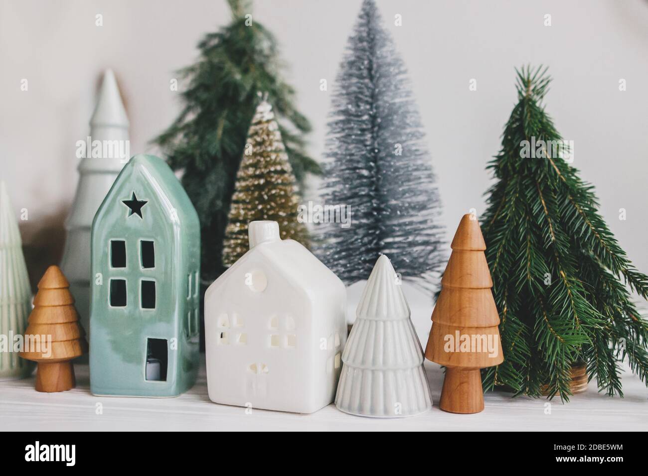 Scène de Noël, village de vacances miniature. Noël petites maisons en  céramique, bois et sapins enneigés sur fond blanc. Décoration moderne  festive Photo Stock - Alamy