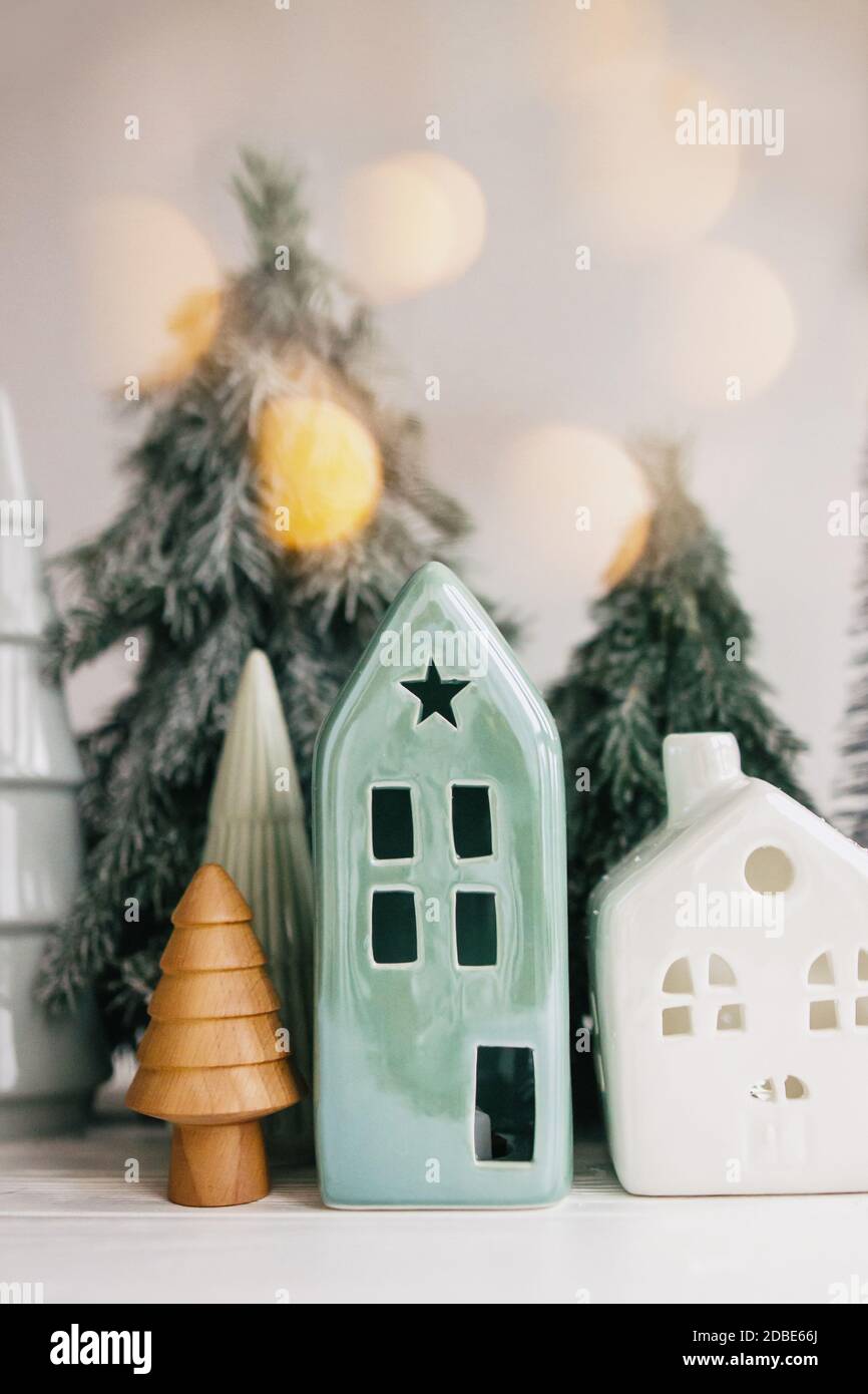 Scène de Noël, village de vacances miniature. Lumières de Noël, petites  maisons en céramique, sapins en bois et enneigés sur fond blanc. Festive  moderne de Photo Stock - Alamy
