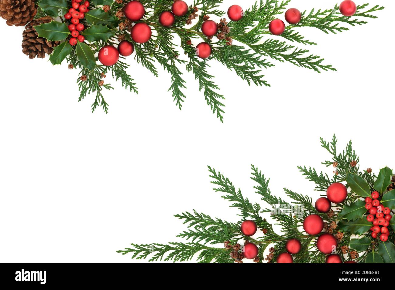 Bordure de Noël avec houx, cyprès de cèdre, cônes de pin et boules rouges sur fond blanc. Motif Noël décoratif pour les fêtes. F Banque D'Images