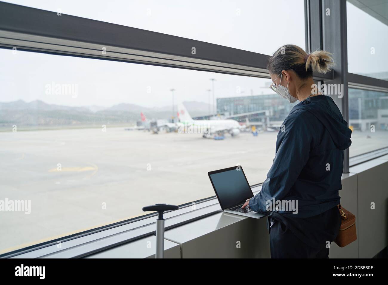 jeune femme asiatique voyageur aérien utilisant un ordinateur portable en attendant pour l'embarquement dans le terminal de l'aéroport Banque D'Images
