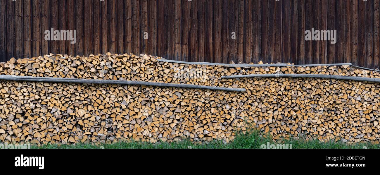 Panorama - gros tas de bois en face d'un mur de la grange en bois Banque D'Images