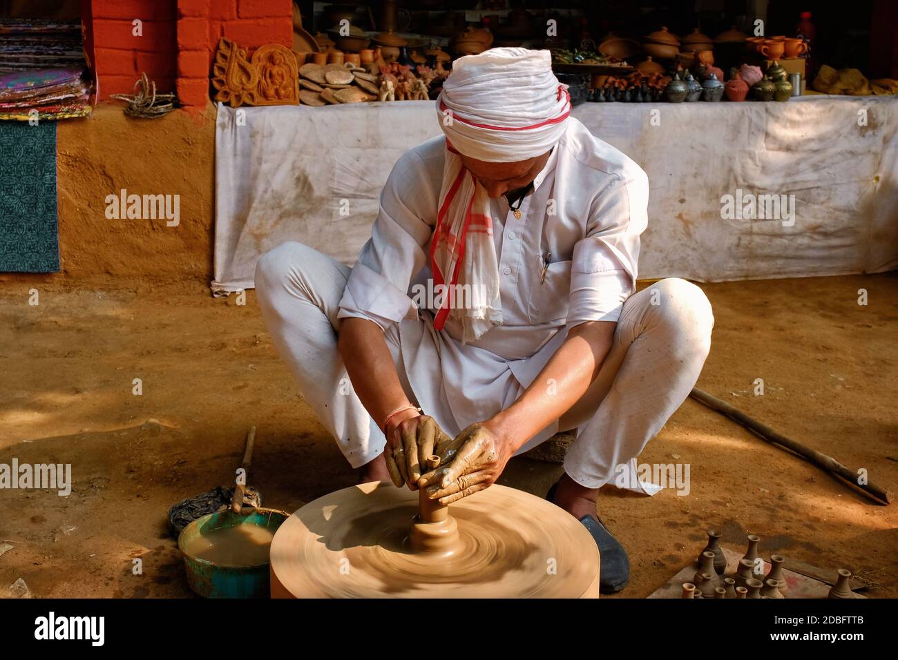 Indian potter à l'œuvre: Lancer la roue de potter et façonner le vaisseau en céramique et l'argile: Pot, pot dans l'atelier de poterie. Maître expérimenté. Poignée Banque D'Images