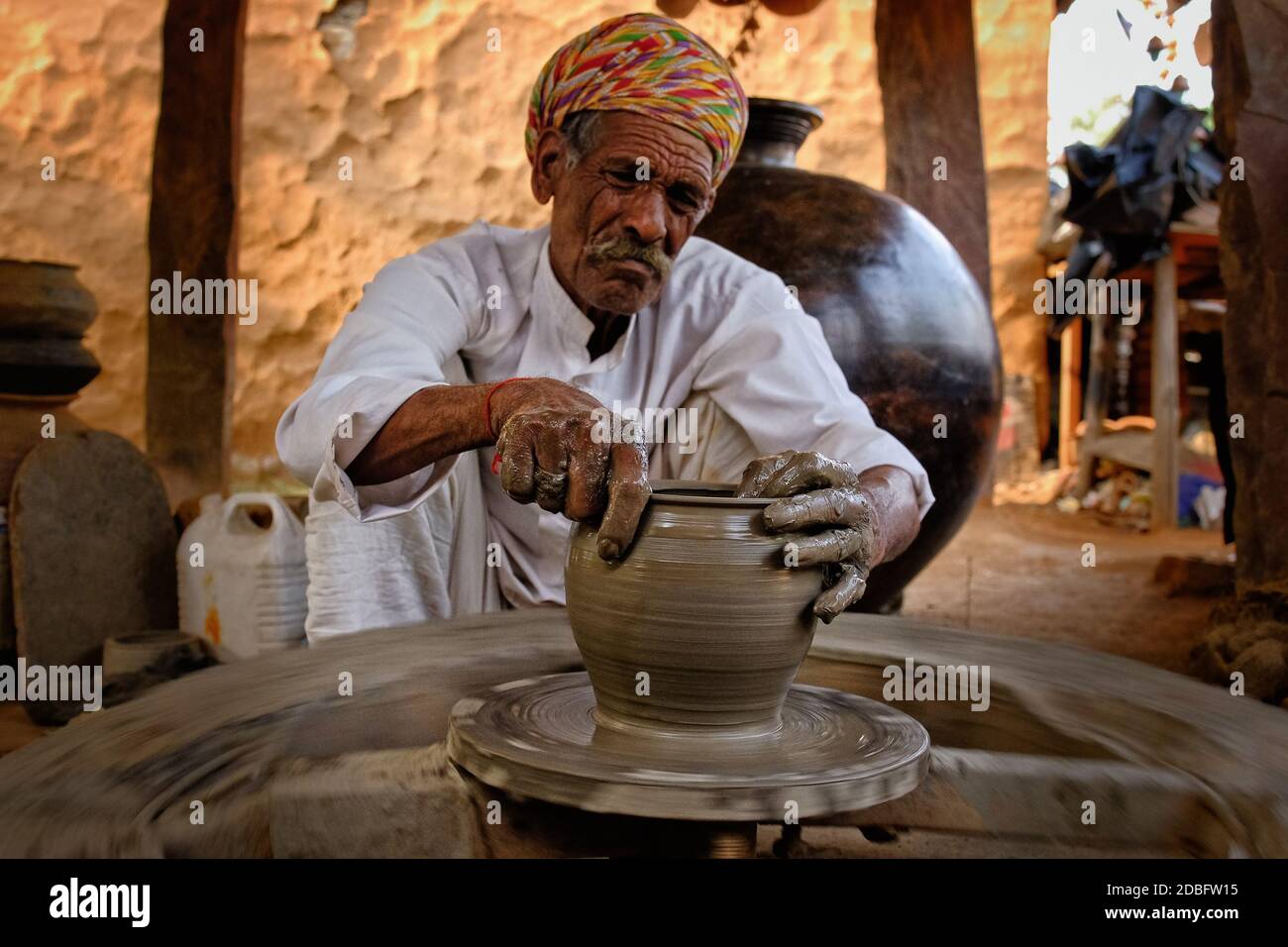 Indian potter à l'œuvre: Lancer la roue de potter et façonner le vaisseau en céramique et l'argile: Pot, pot dans l'atelier de poterie. Maître expérimenté. Poignée Banque D'Images
