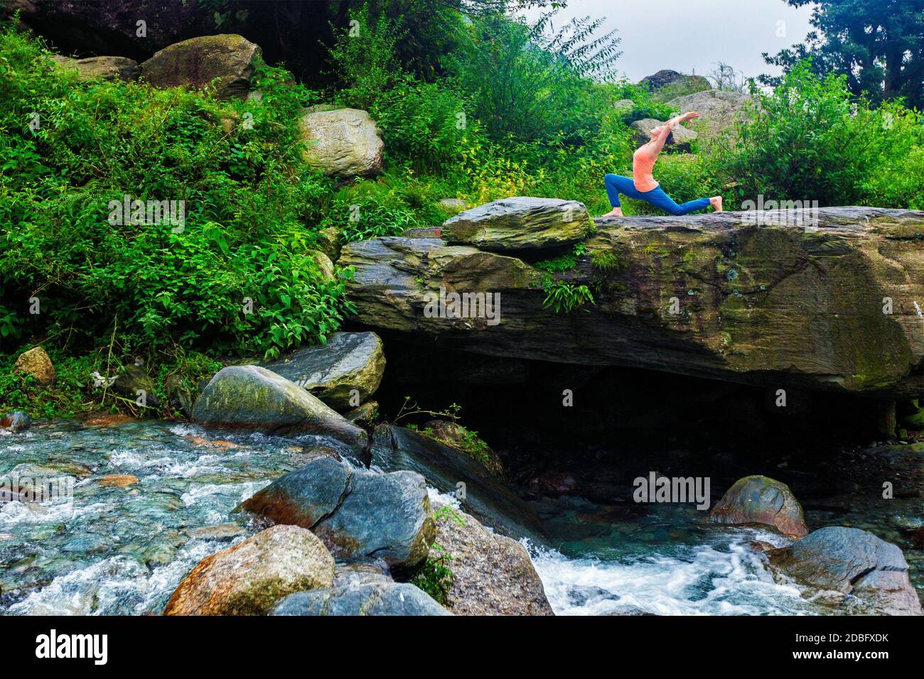 Yoga à l'extérieur - femme sportive pratique yoga Anjaneyasana - fente basse en croissant en plein air dans les montagnes Banque D'Images