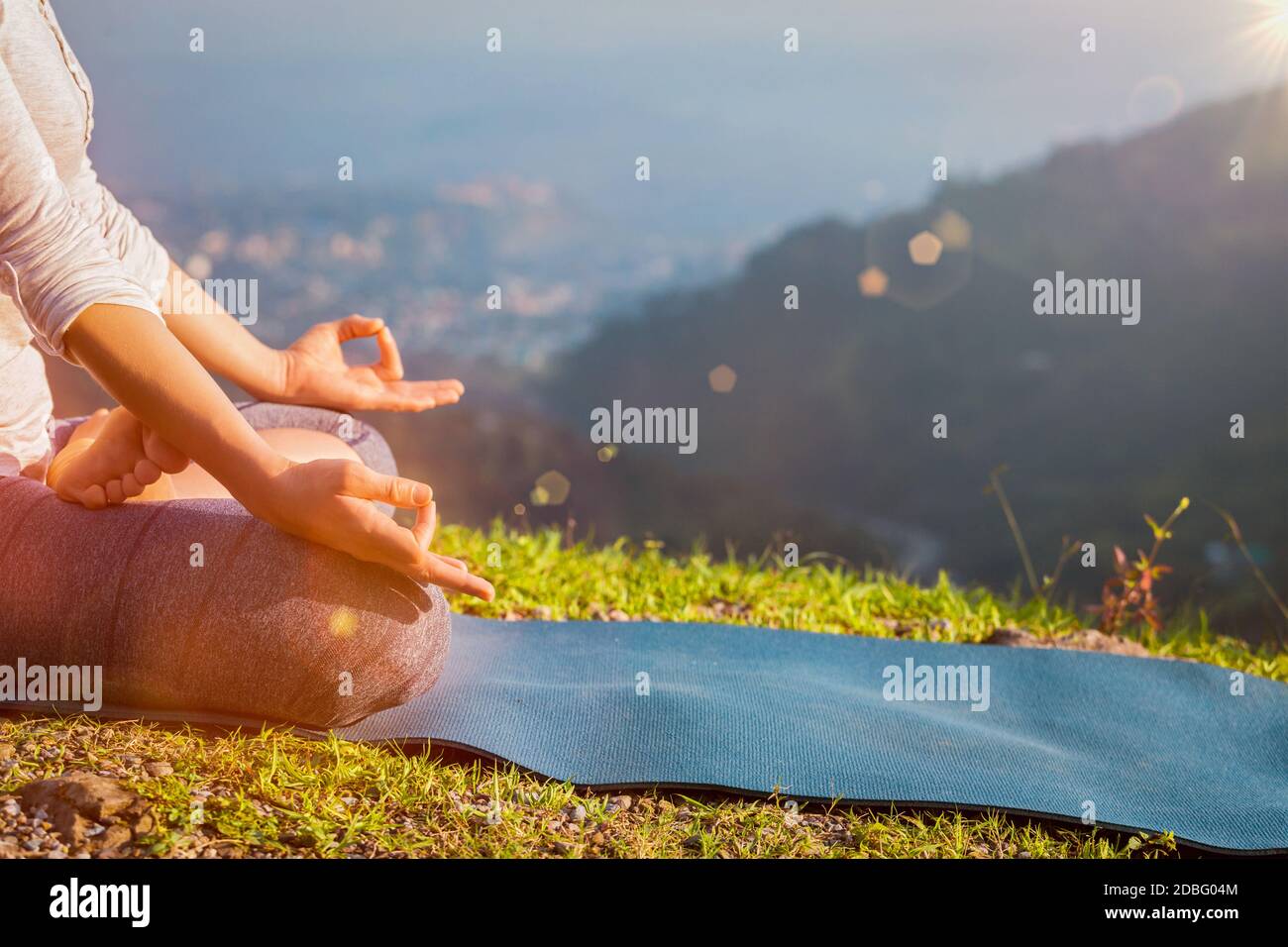 Gros plan de la femme dans Padmasana yoga lotus poser avec le menton mudra à l'extérieur avec l'espace de rédaction. Avec fuite de lumière et évasement de lentille Banque D'Images
