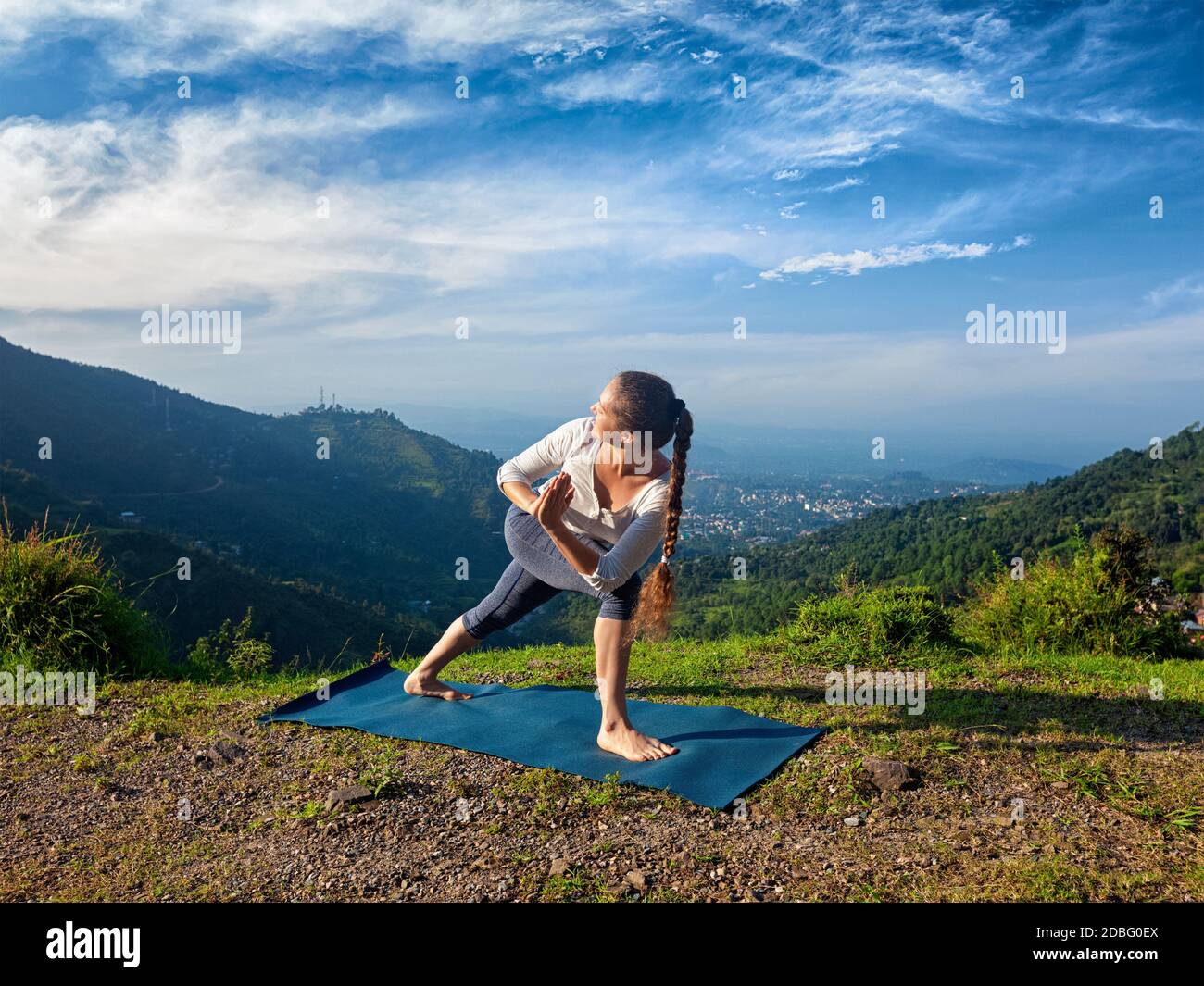 Femme sportive pratique Ashtanga Vinyasa yoga asana Utthita Parsvakonasana varitation - angle latéral étendu pose à l'extérieur dans les montagnes à le plus Banque D'Images