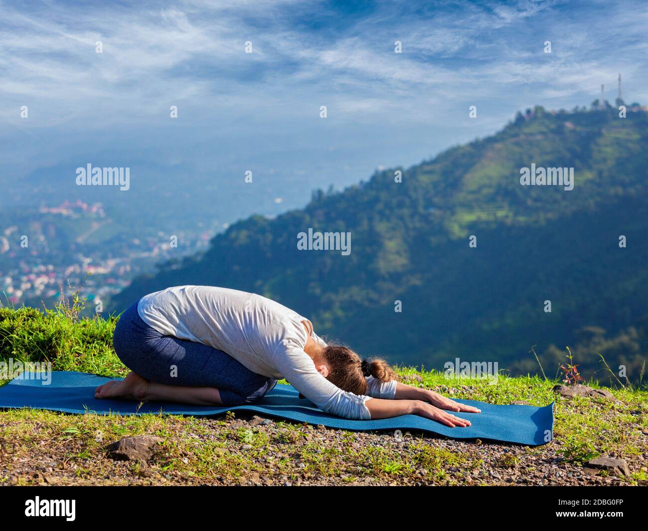 Femme sportive pratique le yoga asana Balasana - pose d'enfant à l'extérieur, en montagne Banque D'Images