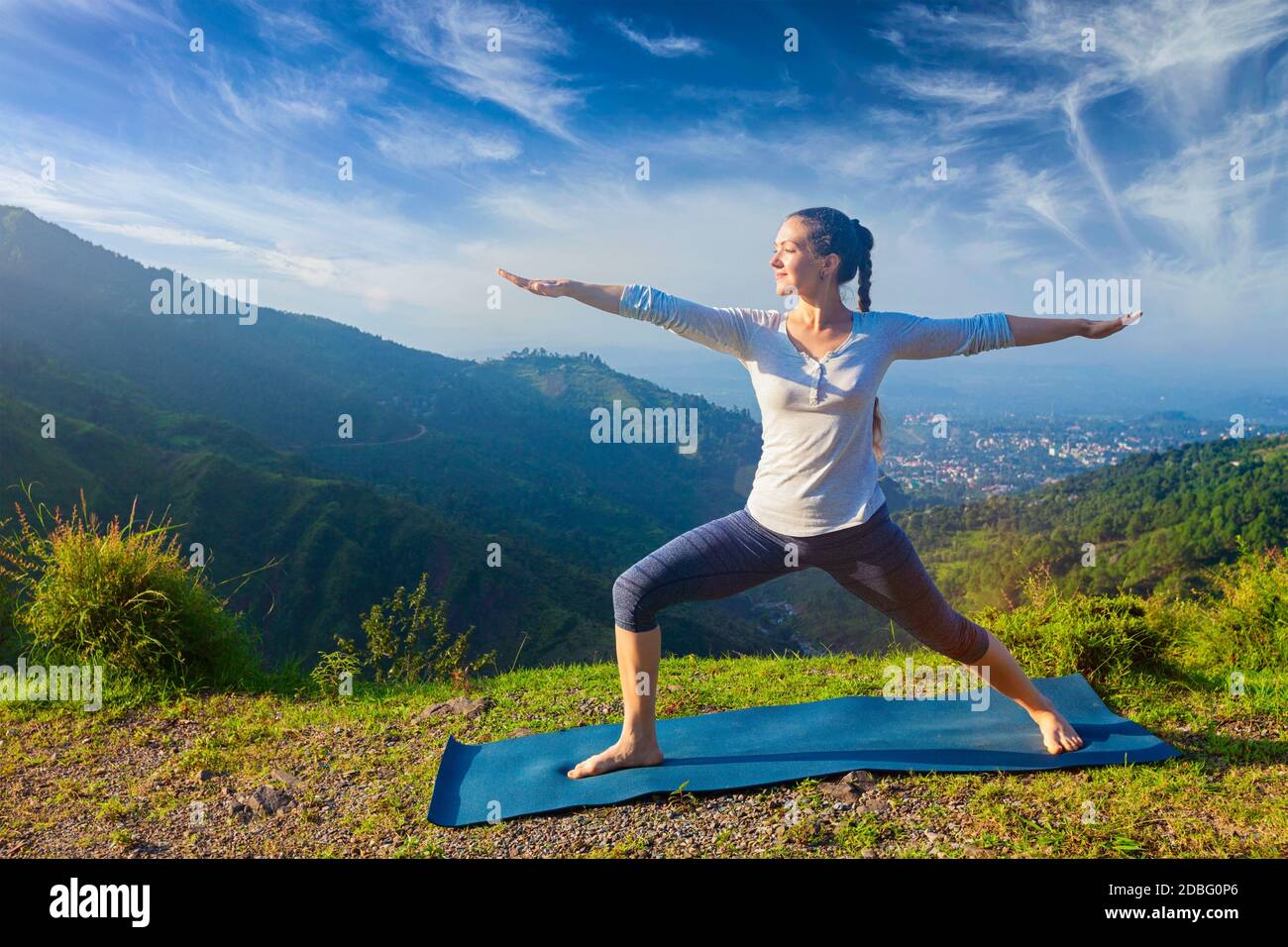 Yoga à l'extérieur - femme sportive faisant yoga asana Virabhadrasana 2 - posture du guerrier en plein air dans les montagnes de l'Himalaya dans le matin Banque D'Images