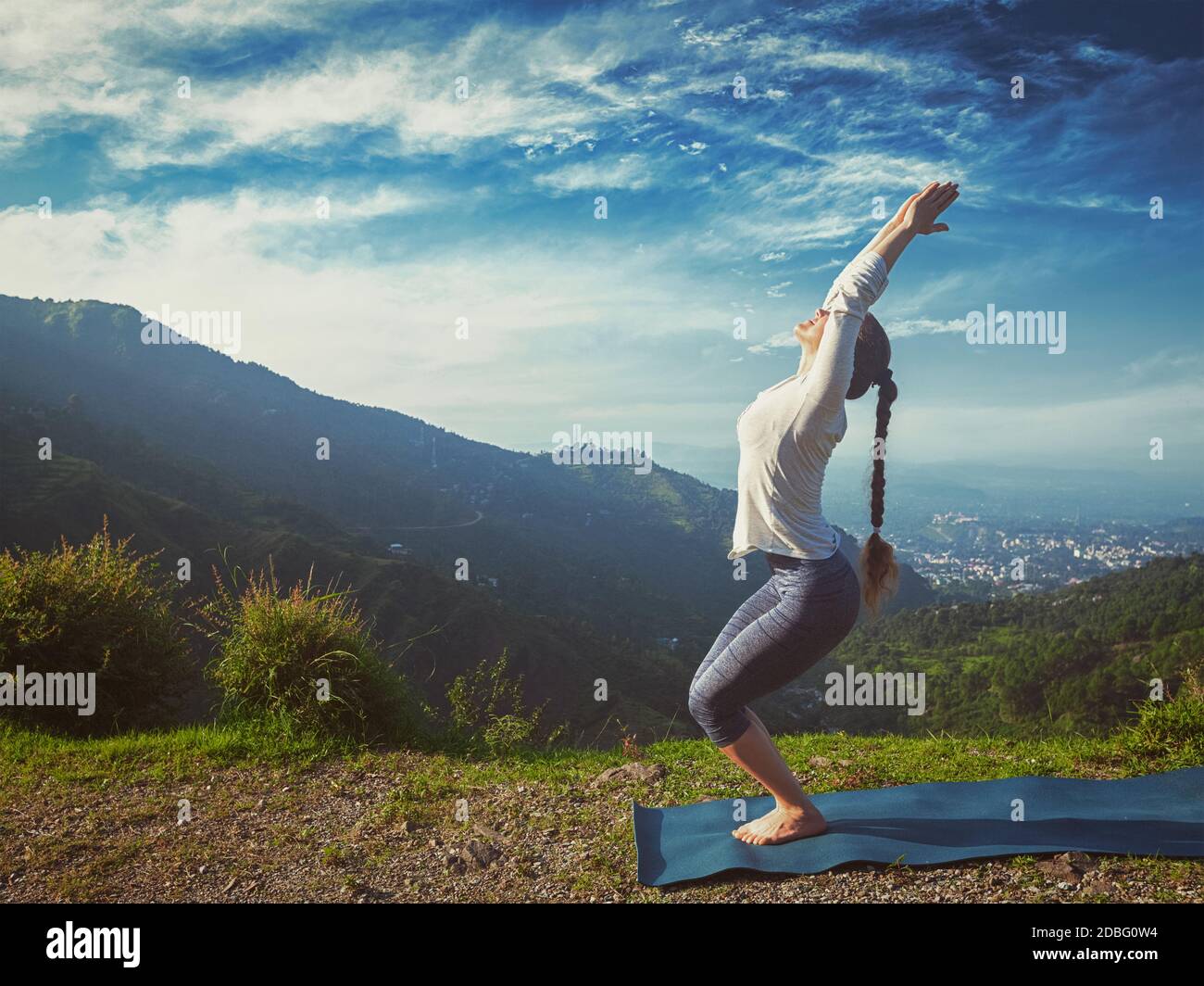 Style boxer rétro vintage avec coupe sportive pour les jeunes Femme faisant du yoga asana Utkatasana (pose de chaise) Plein air dans les montagnes Himalaya dans le plus Banque D'Images