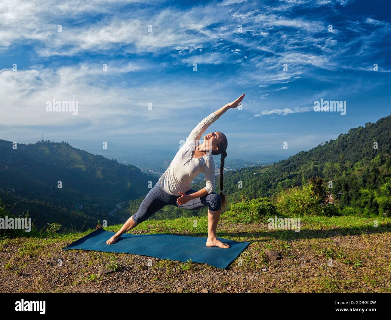 Femme sportive pratique le yoga asana Utthita Parsvakonasana - étendu posture latérale à l'extérieur dans les montagnes le matin Banque D'Images