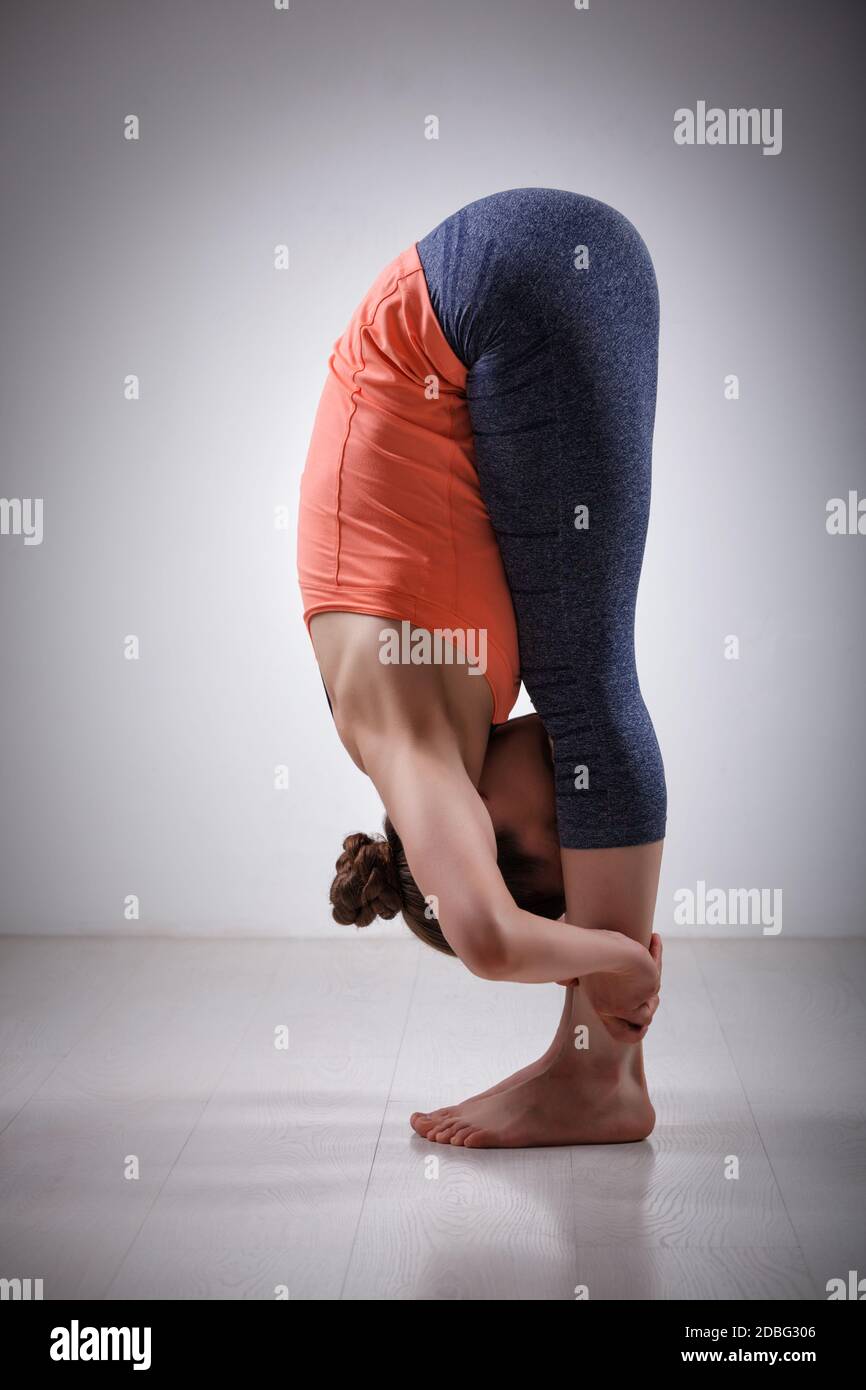 Belle tenue sportive yogini femme pratique yoga asana Uttanasana - posture du virage debout vers l'avant Banque D'Images