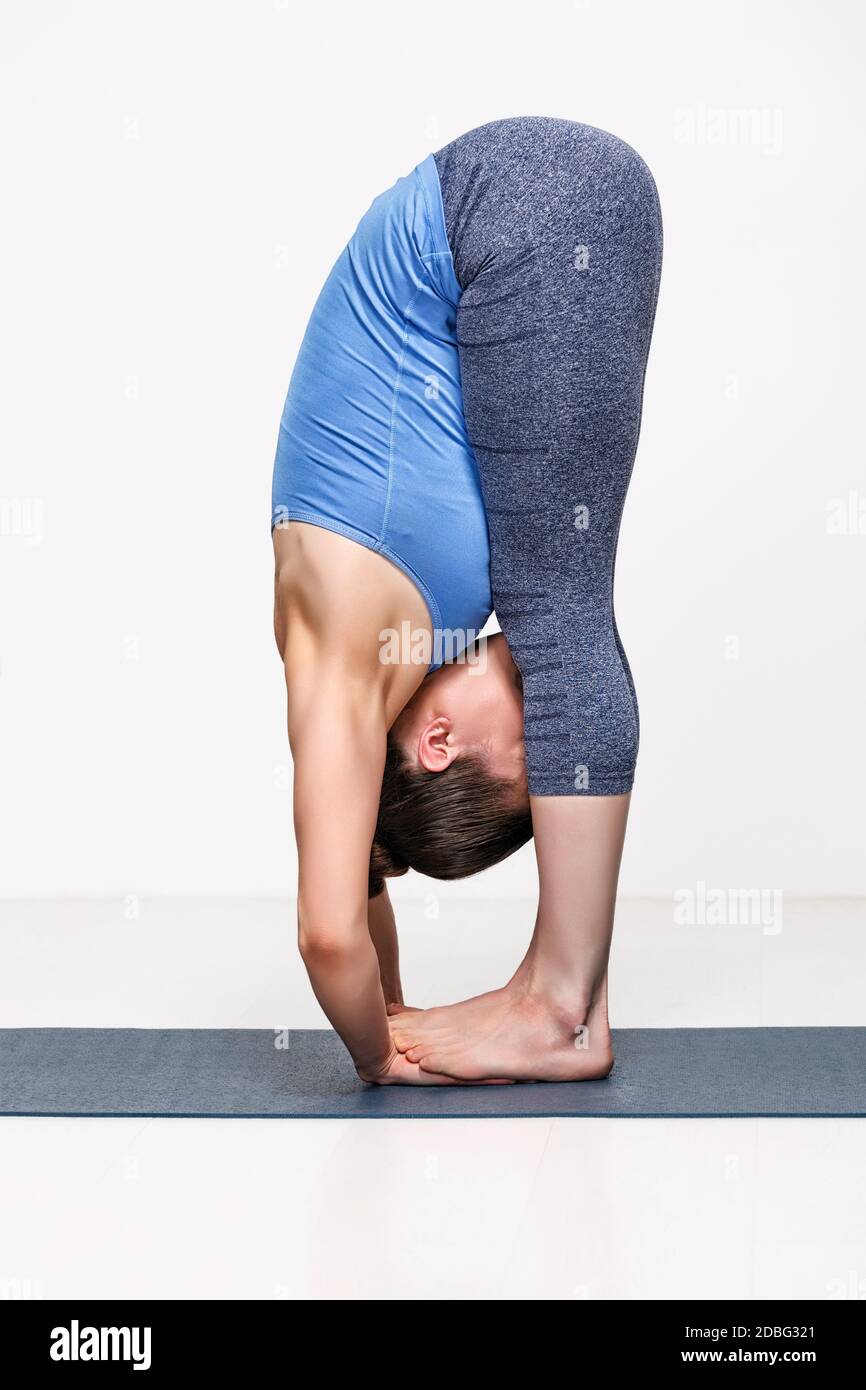 Femme sportive pratique le yoga asana Padahastasana - debout en avant pliez la main sous les pieds Banque D'Images