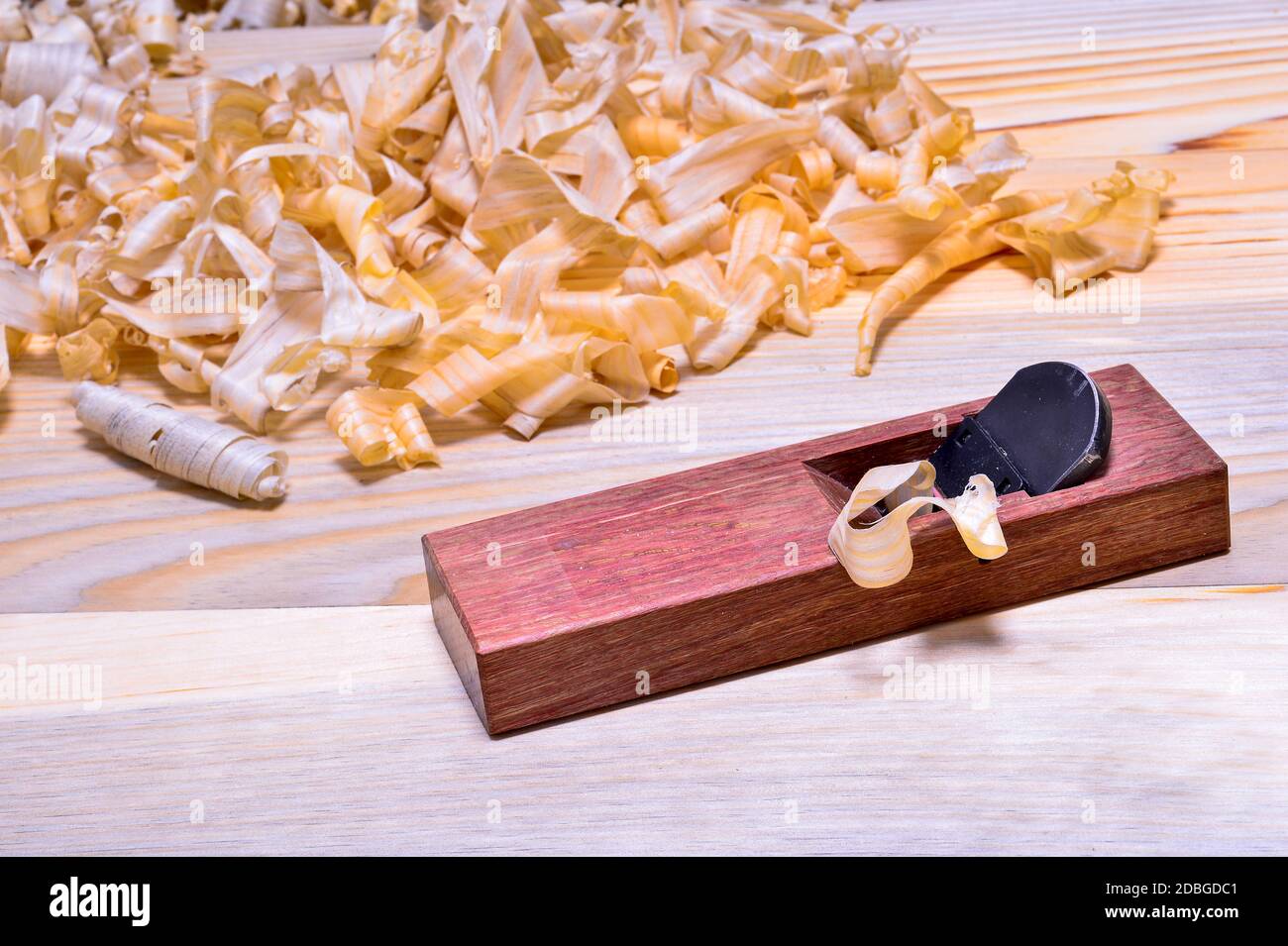 Plan japonais en bois de chêne rouge avec pile de copeaux sur une surface lisse en bois. Arrière-plan. Banque D'Images