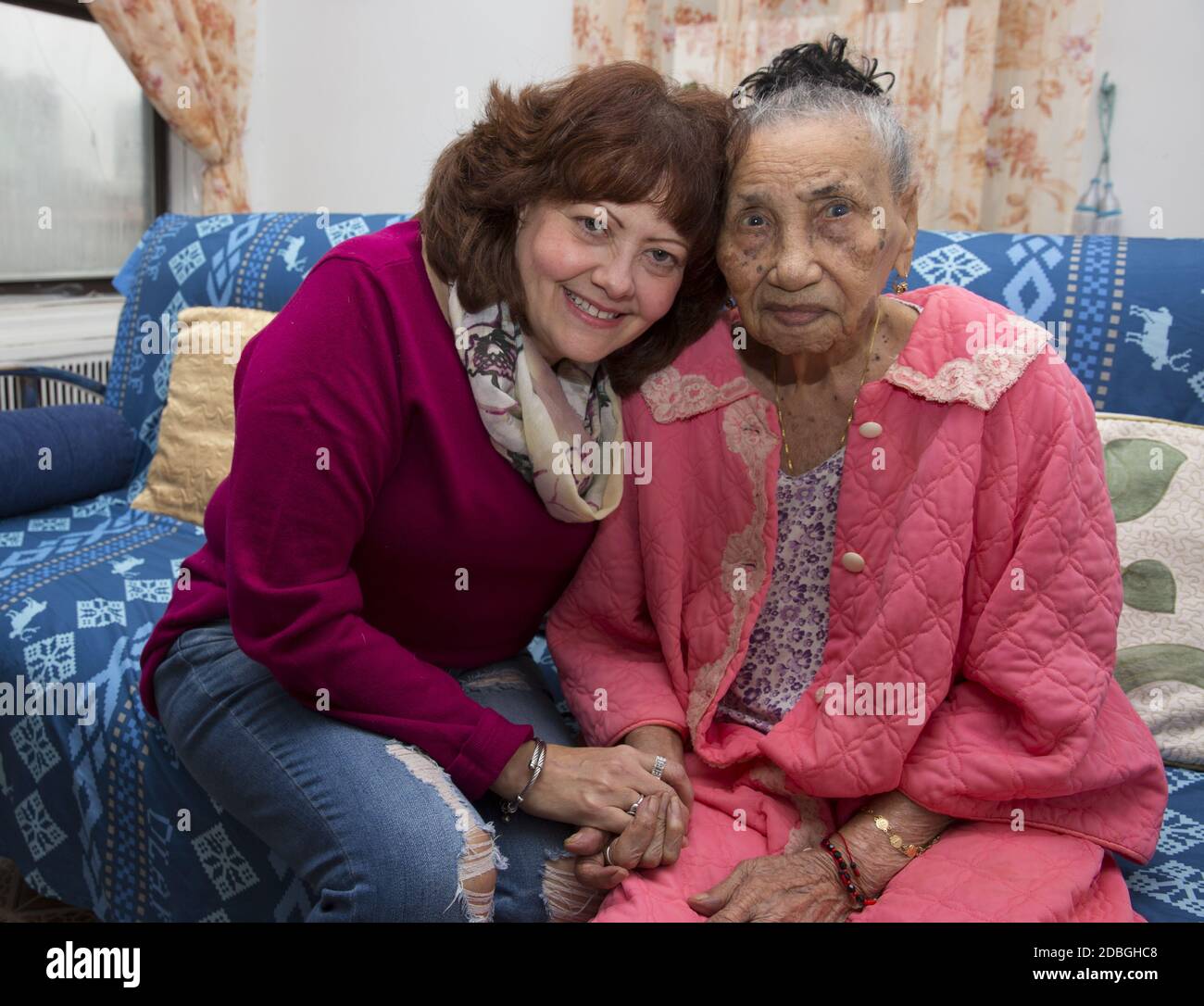Portrait d'une femme de cent ans avec sa travailleuse sociale qui la vérifie régulièrement, chez elle à East Harlem, New York. Banque D'Images