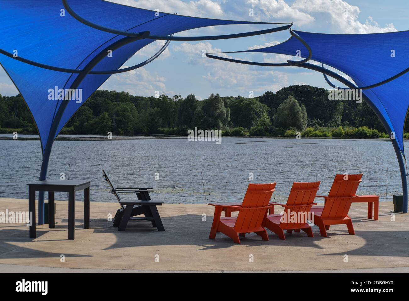 Chaises Adirondack, disposées au bord du lac, sous une paire d'auvents de style moderne Banque D'Images