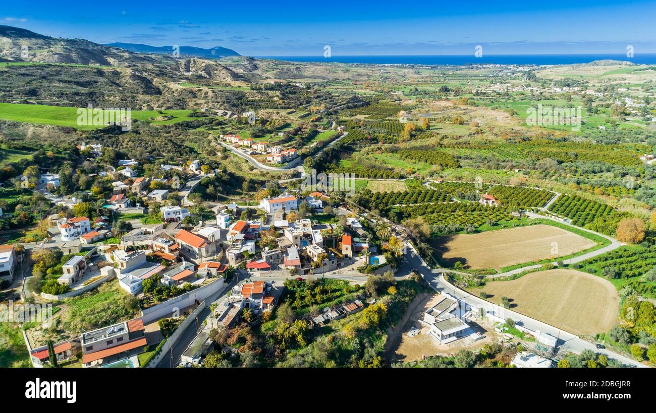 Oiseau de l'antenne de Goudi village de Polis Chrysochous valley, Paphos, Chypre. Avis de carreaux de céramique traditionnelles maisons de toit, l'église, arbres, collines Banque D'Images