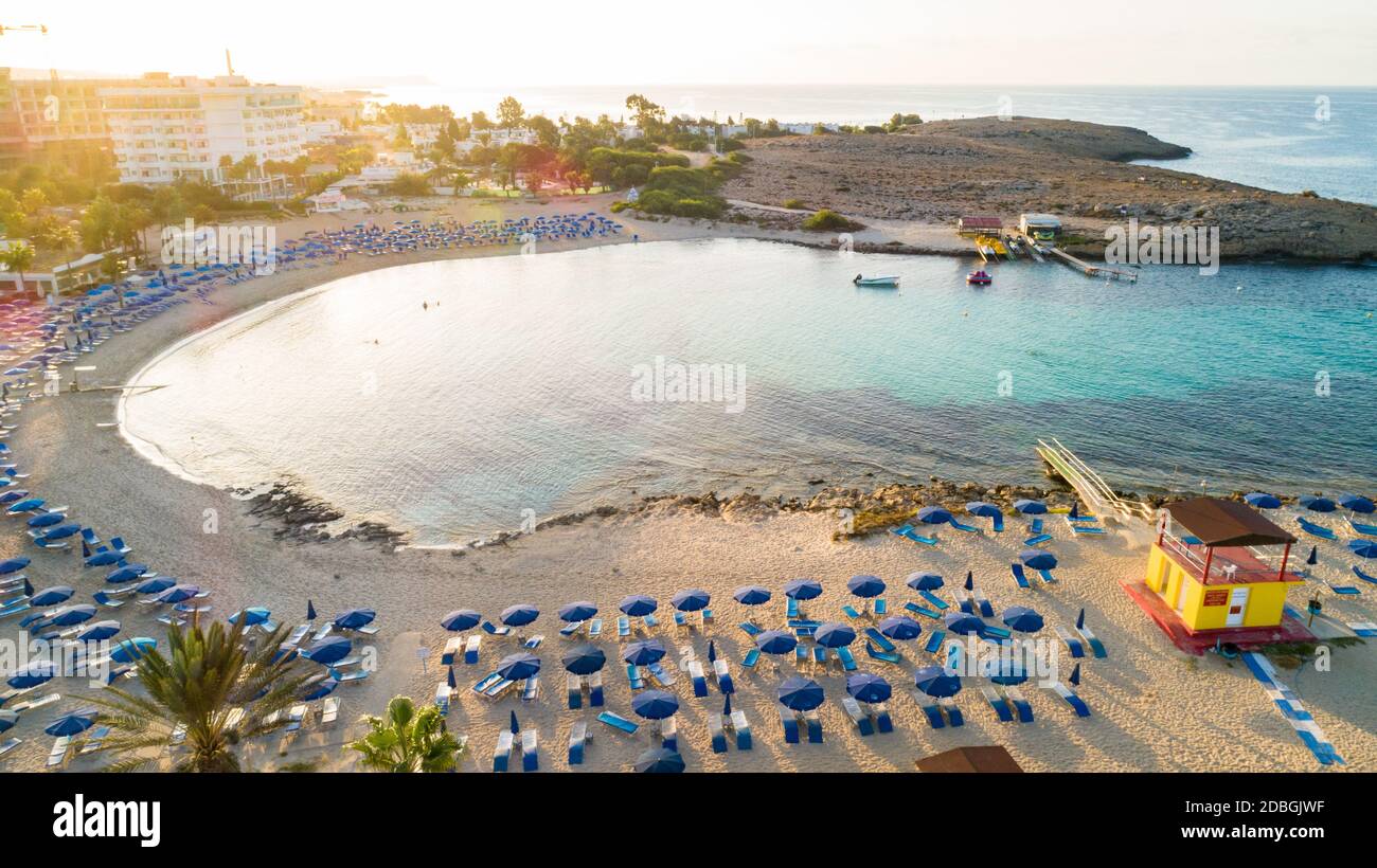 Vue panoramique sur la plage de Vathia Gonia, Ayia Napa, Famagusta, Chypre. L'attraction touristique historique baie rocheuse au lever du soleil avec sable doré, soleil Banque D'Images
