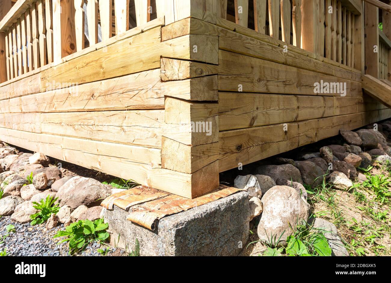 Coin de la maison en bois sur la base de pierre de support Banque D'Images