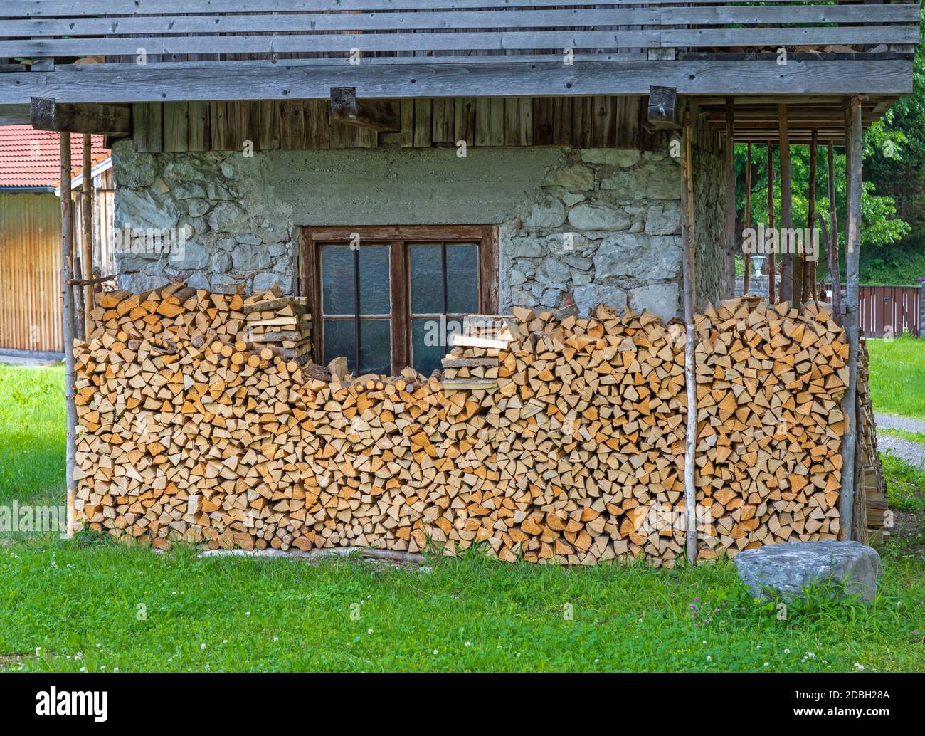 Maison avec bois de chauffage frais superposés en Bavière Banque D'Images