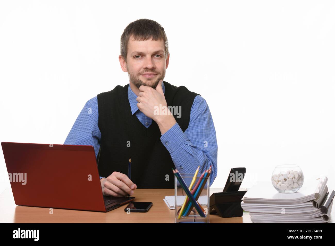 Un homme confiant s'assoit à l'ordinateur sur un fond blanc Banque D'Images