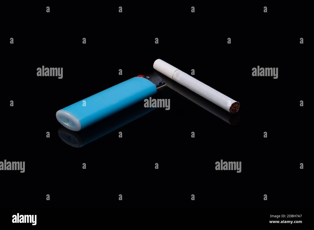 une cigarette blanche à filtre et un allume-cigare bleu gaz en plastique sur un fond noir isolé avec réflexion Banque D'Images