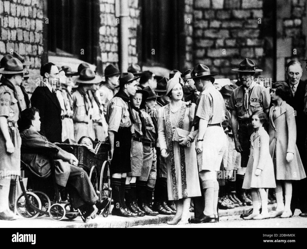 La reine Elizabeth, la princesse Margaret Rose et la princesse Elizabeth (à droite) accueillent un groupe de scouts alignés devant leur maison. Banque D'Images