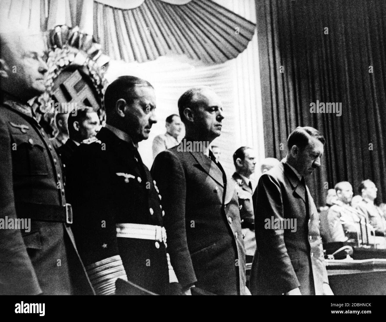 Hitler à la session du Reichstag, où il a déclaré la défaite de l'URSS imminente. A côté de lui sont Joachim von Ribbentrop, Erich Raeder et Walther von Brauchitsch. Celui-ci a été tenu responsable par Hitler de la défaite de l’Union soviétique et a été placé dans la Réserve de FuehrerReserve (la « Réserve des officiers ») , et n’a reçu aucune affectation avant la fin de la guerre. En arrière-plan se trouvent le président du Reichstag Hermann Goering et l'adjudant d'Hitler Julius Schaub. Banque D'Images