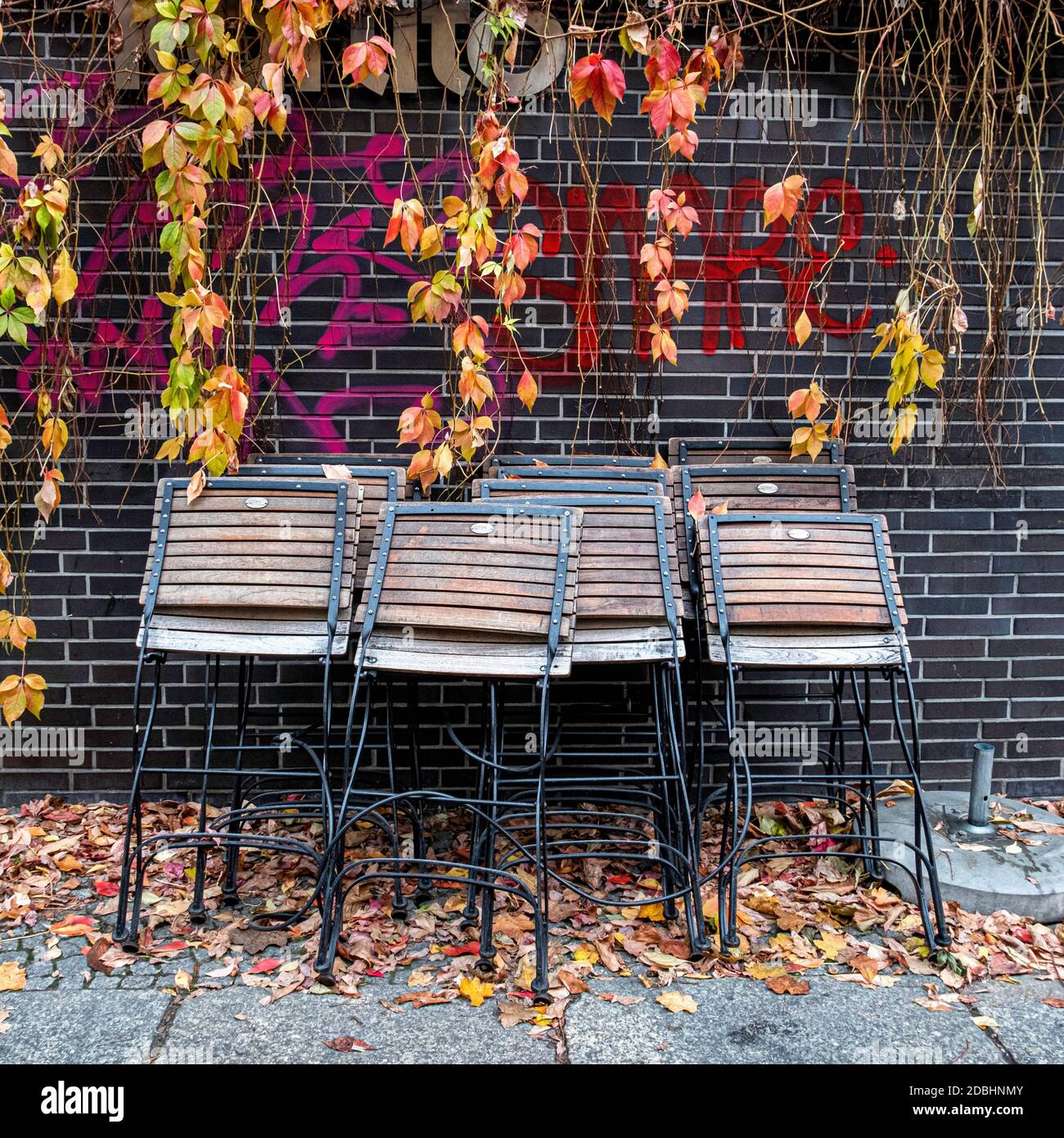 Feuilles d'automne vibrantes, grafitti et chaises pliées à l'extérieur fermé restaurant Karlito pendant l'écluse épidémique Corona, Mitte, Berlin Banque D'Images