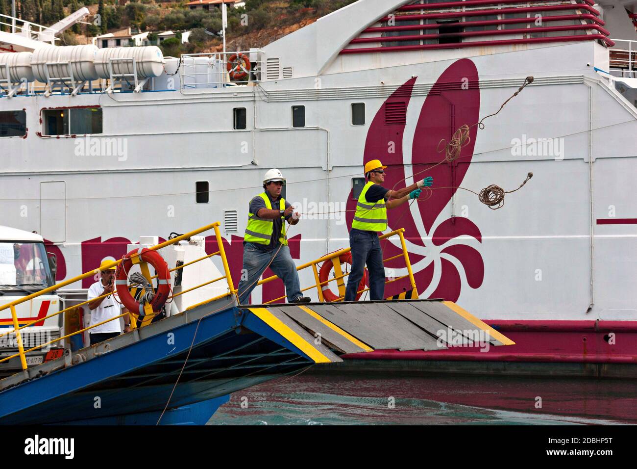 Bateau crewmen jetant des lignes d'amarrage, Porto Santa Stefano, Toscane, Italie Banque D'Images