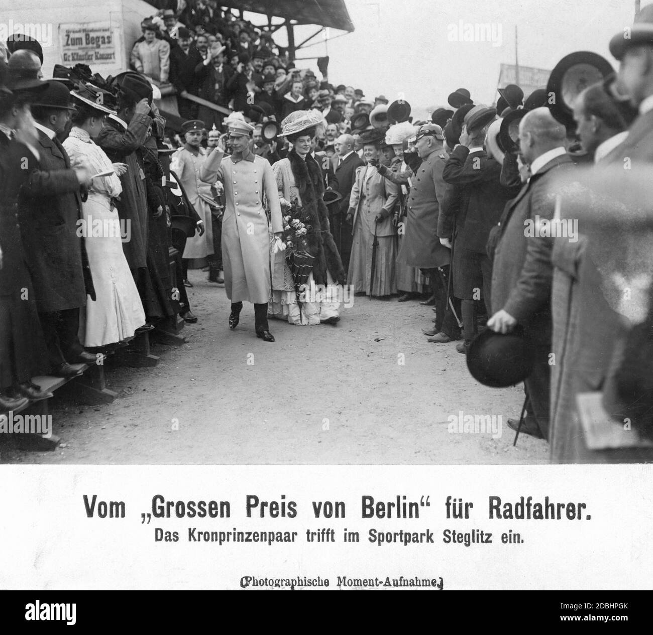 Le prince héritier allemand Wilhelm arrive avec sa femme Caecilie sur le circuit de Berlin Stegliz pour le Grand Prix de Berlin pour cyclistes, où il est accueilli par un garde et les autres invités. Banque D'Images