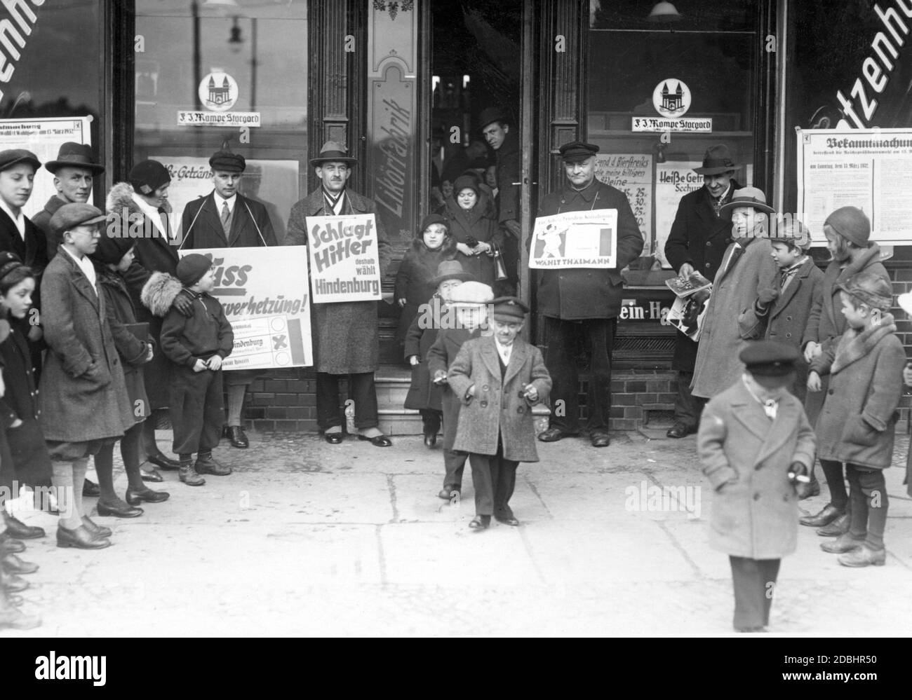 Midgets quittant le bureau de vote au deuxième tour de scrutin. Devant le site du scrutin se trouvent les partisans des candidats qui font campagne avec leurs affiches électorales. Banque D'Images