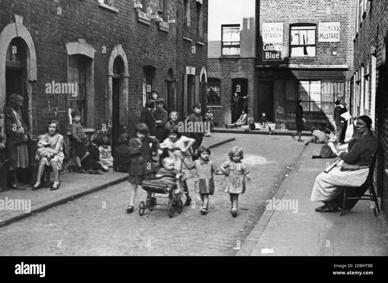Des enfants dans une rue dans une partie plus pauvre de Londres pendant la Grande Dépression des années 1930. Banque D'Images