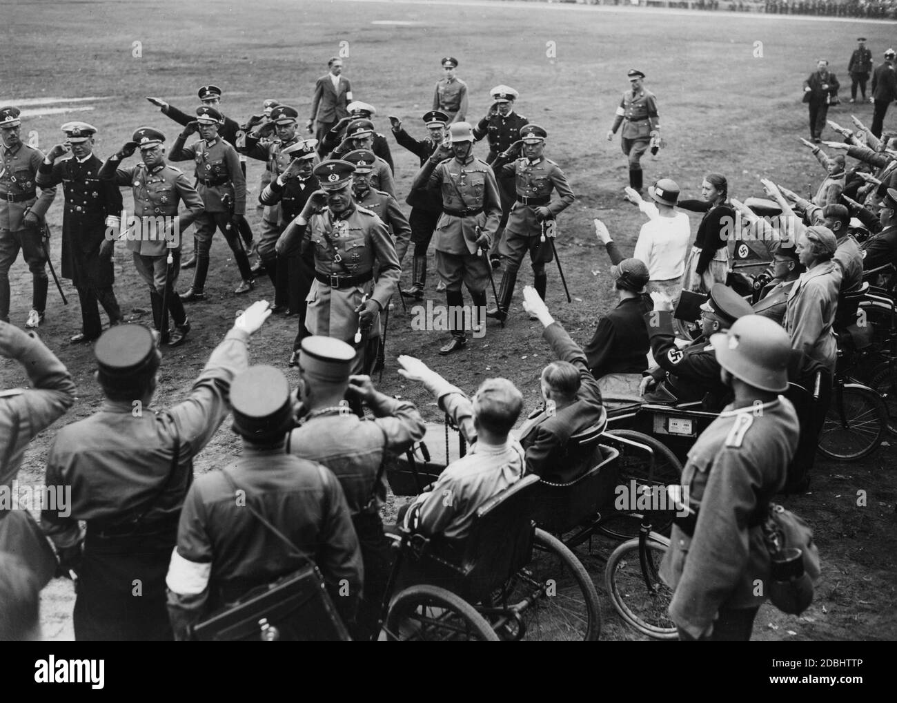 Le jour de la Reichswehr sur le champ de Zeppelin, Werner von Blomberg (devant), l'amiral Erich Raeder (à gauche) et Werner von Fritsch saluent les personnes handicapées, dont certaines en uniforme nazi. Banque D'Images