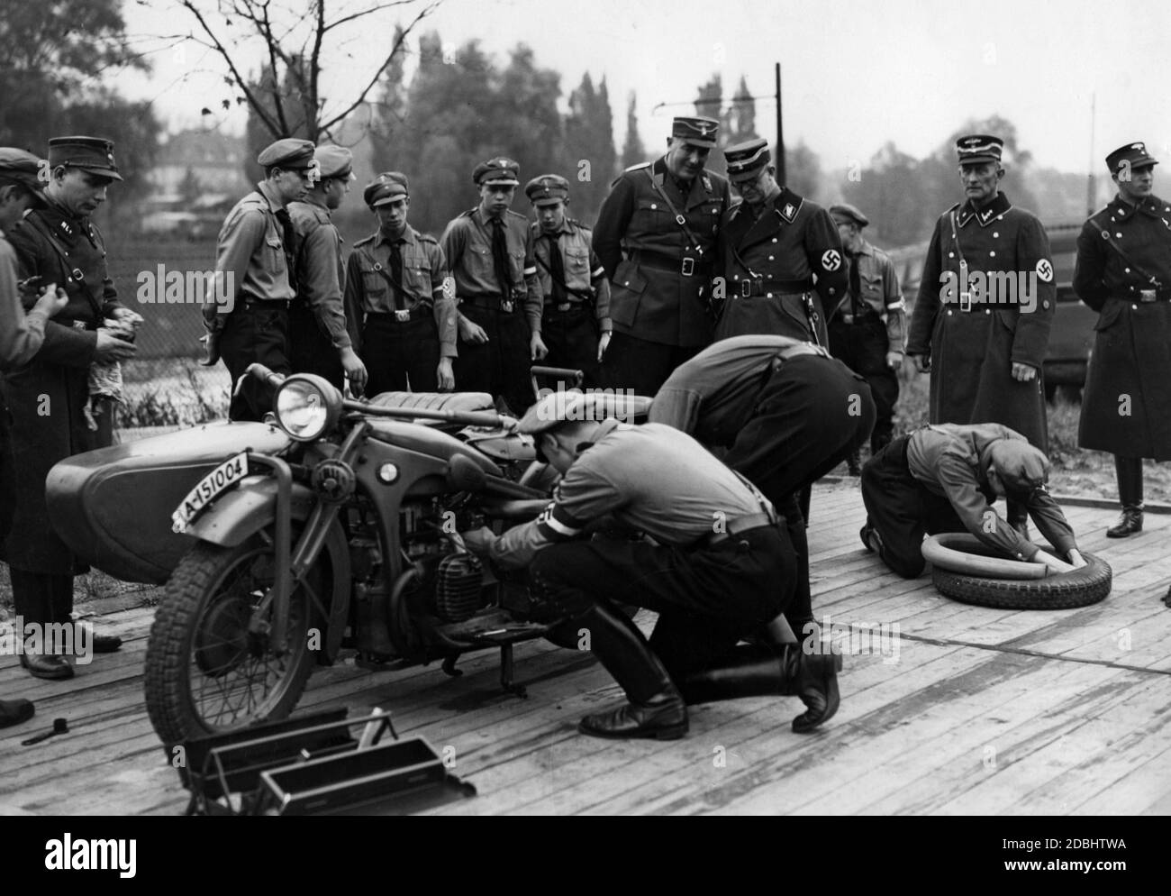 Membres du Motor HJ à Lichterfelde Ost lors de leur examen final. Ils travaillent sur une moto tandis que les membres du NSKK les regardent. La moto est une BMW R4. Banque D'Images