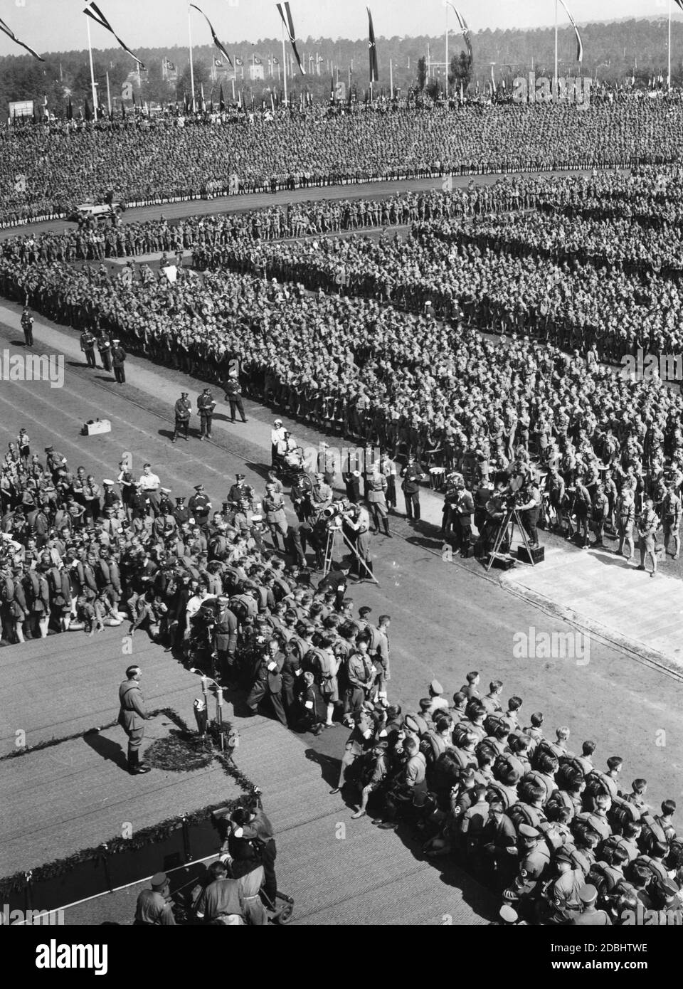 Adolf Hitler prononce un discours au stade municipal de Nuremberg lors du rassemblement de la jeunesse hitlérienne lors du Congrès du Parti nazi. L'événement est filmé par plusieurs équipes de tournage et photographes. Banque D'Images