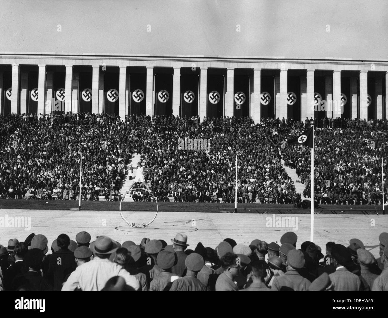 Au festival folklorique sur le terrain de Zeppelin à l'occasion du Congrès du Parti nazi, un gymnaste effectue des exercices sur la roue de gym. Banque D'Images