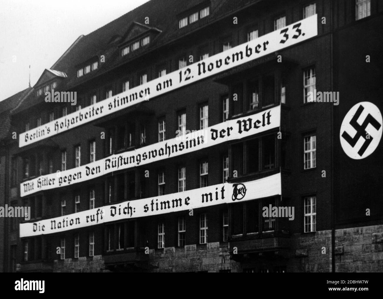 'Une bannière avec l'inscription ''les travailleurs du bois de Berlin votent avec Hitler le 12 novembre 1933 contre la folie d'armement du monde. La nation vous appelle : ''votez avec oui'' au bâtiment syndical du Syndicat allemand des travailleurs du bois (plus tard un bâtiment DAF et aujourd'hui l'Université psychologique de Berlin) au cours de la campagne électorale du Reichstag et du référendum sur le retrait de la Société des Nations le 12 novembre 1933.' Banque D'Images